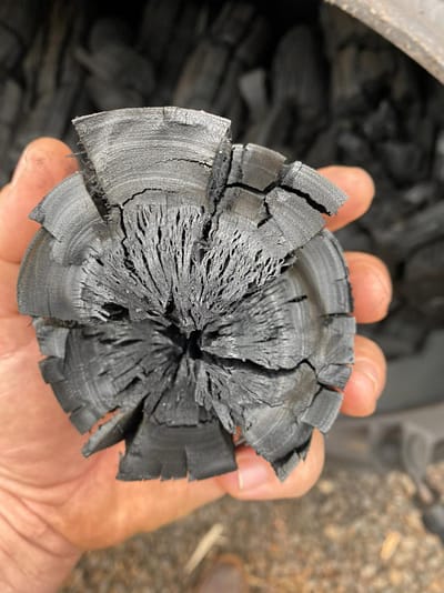 Biochar from kiln in hand before crushing.